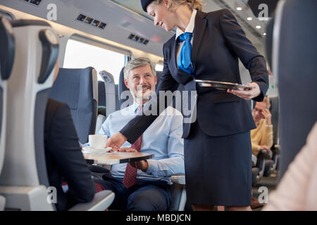 Weibliche Telefonzentrale mit Kaffee zu Geschäftsmann auf Personenzug Stockfoto