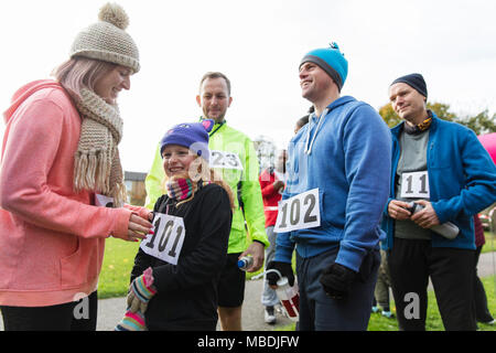 Mutter pinning Marathon bib auf die Tochter, die an der Spendenaktion Stockfoto