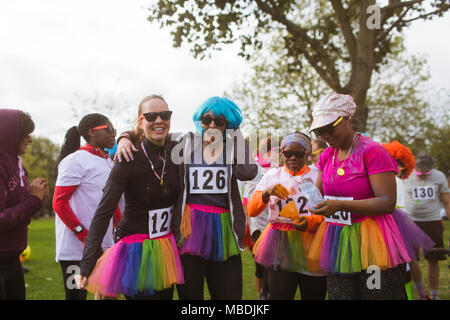 Portrait verspielten Läuferinnen mit Perücken und TUTUS an der Nächstenliebe laufen im Park Stockfoto