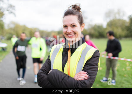 Portrait lächelnd weibliche Freiwillige auf spendenlauf in Park Stockfoto