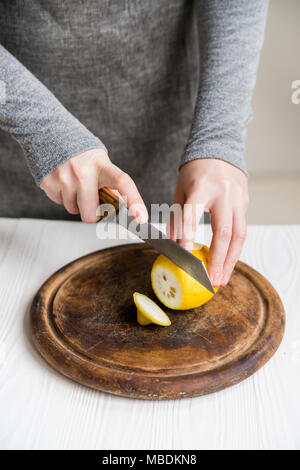 Frau schneidet Zitrone in Scheiben schließen Stockfoto