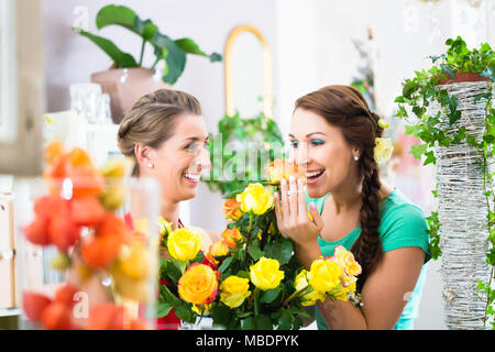 Frauen in Blumenladen Genießen der Rosen Stockfoto