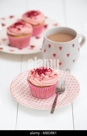 Himbeere Cupcakes auf einem Teller mit einer Tasse Kaffee Stockfoto