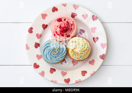 Bunten Cupcakes auf einem herz-muster Platte Stockfoto