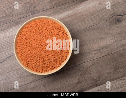 Trocken rote Linsen in einer Schale auf Holz- Hintergrund. Ansicht von oben. Stockfoto