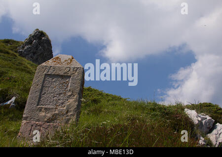 Ein Grabstein, mit Blick auf einen starken Rückgang auf die Spitze des Monte Baldo, Italien Stockfoto