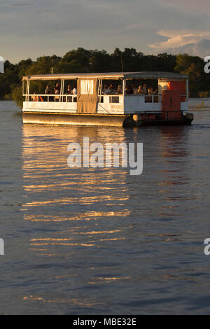 Ein Boot während eine Sunset Cruise auf dem Sambesi Fluss in der Nähe von Victoria Falls in Simbabwe. Die Sunset Kreuzfahrten bieten die Möglichkeit anzeigen Wildtiere und Vögel. Stockfoto