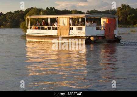 Ein Boot während eine Sunset Cruise auf dem Sambesi Fluss in der Nähe von Victoria Falls in Simbabwe. Die Sunset Kreuzfahrten bieten die Möglichkeit anzeigen Wildtiere und Vögel. Stockfoto