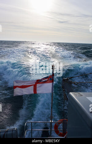 Eine britische White Ensign fliegen von der Rückseite der Royal Navy HMS Dasher P 2000 P280 im Sonnenlicht. Stockfoto