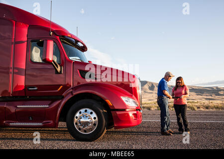 Husbaand und Frau fahren Team Ihre Rundfahrt Kontrolle beim Stehen vor Ihren Lkw. Stockfoto