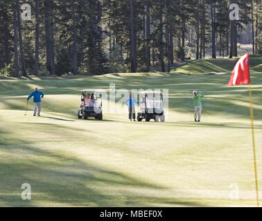 Zwei ältere Paare Golf spielen auf einem Golfplatz. Stockfoto