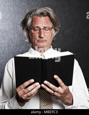 Studio Portrait der kaukasischen Mann Schauspieler halten und lesen ein Buch. Stockfoto
