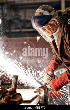 Fabrikarbeiter Schleifen einer Kante in einem Sheet Metal Factory. Stockfoto