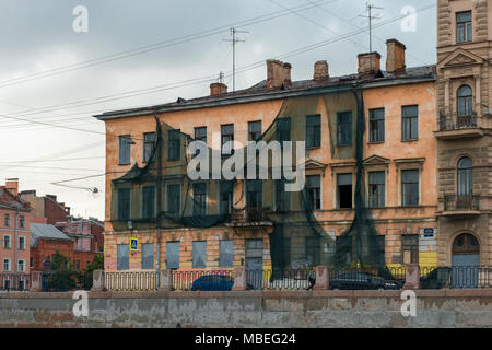 Russland, SANKT PETERSBURG - 18. AUGUST 2017: Kryukov Canal Embankment, 28. Altes Haus gedeckte Gebäude Fassade mesh. Die Vorbereitungen für die renovatio Stockfoto