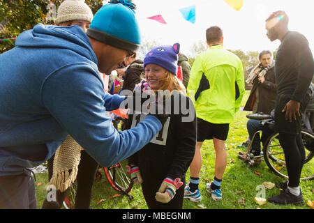 Vater pinning Marathon bib auf die Tochter, die an der Spendenaktion in Park Stockfoto