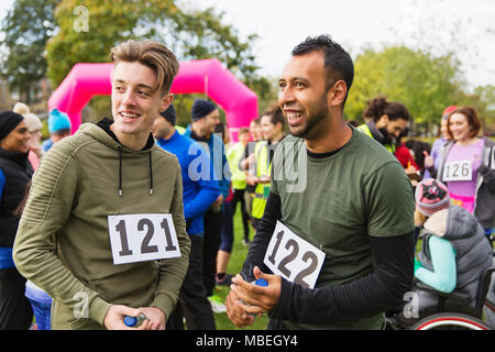 Männliche Läufer mit dem Sprechen, nachdem Spendenlauf in Park Stockfoto