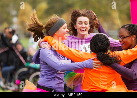 Begeisterte Läuferinnen finishing Spendenlauf, Feiern Stockfoto