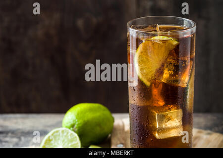 Cuba Libre. Cocktail mit Rum, Limetten und Eis auf Holztisch. Stockfoto