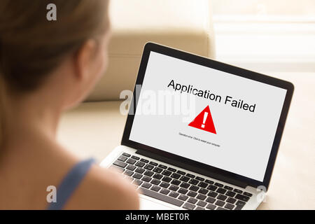 Mädchen auf der Suche nach Laptop mit Anwendung fehlgeschlagen Fehler auf dem Bildschirm. Software Fehler, App aufgehört zu arbeiten, Rechnereinheit brach, Systemabsturz unexpectedl Stockfoto