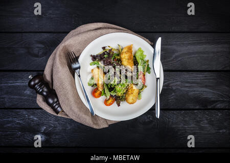 Salat mit Lachs in Blätterteig mit Salat und Sesam. Stockfoto