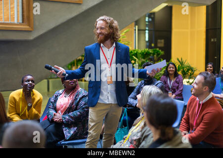 Lächelnd Sprecher männlich mit Mikrofon zu sprechen Konferenz Publikum Stockfoto