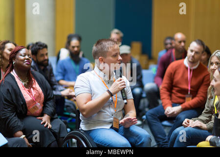 Weibliche Sprecher im Rollstuhl mit Mikrofon zu sprechen Publikum Stockfoto