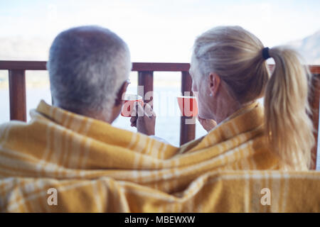 Gemütliche Paar in der Decke eingewickelt, trinken Kaffee auf dem Balkon Stockfoto