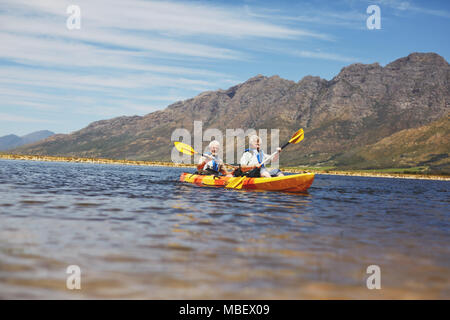 Active Senior paar Kajakfahren auf sonnigen Sommer See Stockfoto