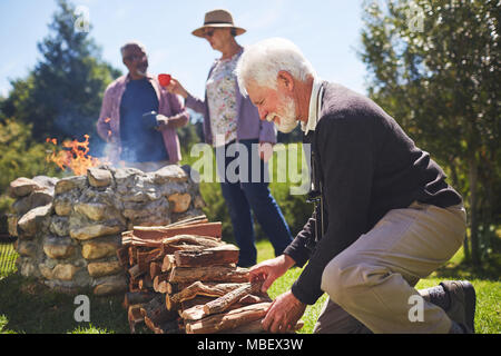 Aktive ältere Menschen stapeln Brennholz Stockfoto