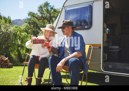 Active Senior paar Kaffee trinken außerhalb Wohnmobil im sonnigen Sommer Campingplatz Stockfoto