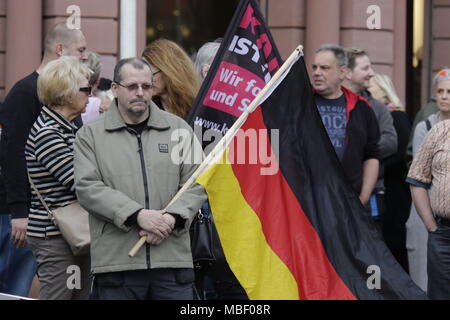 Mainz, Deutschland. 09 Apr, 2018. Ein rechter Demonstrant trägt eine deutsche Flagge. Rund 50 Rechtsextreme Demonstranten in der Innenstadt von Mainz sammelte, gegen die deutsche Regierung zu protestieren, für die Schließung der Grenzen und gegen Flüchtlinge unter dem Motto goÕ ÔMerkel hat. Sie wurden von rund 400 Zähler Gehechelt-Demonstranten. Quelle: Michael Debets/Pacific Press/Alamy leben Nachrichten Stockfoto