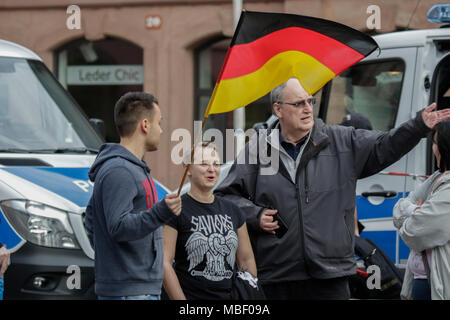 Mainz, Deutschland. 09 Apr, 2018. Ein rechter Demonstrant trägt eine deutsche Flagge. Rund 50 Rechtsextreme Demonstranten in der Innenstadt von Mainz sammelte, gegen die deutsche Regierung zu protestieren, für die Schließung der Grenzen und gegen Flüchtlinge unter dem Motto goÕ ÔMerkel hat. Sie wurden von rund 400 Zähler Gehechelt-Demonstranten. Quelle: Michael Debets/Pacific Press/Alamy leben Nachrichten Stockfoto