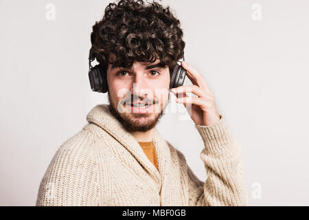 Ein junger stattlicher Mann mit Kopfhörern in einem Studio. Close Up. Stockfoto
