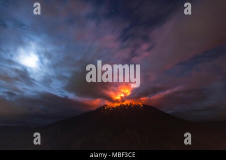 QUITO, ECUADOR - März 4, 2016: Vulkan Tungurahua ist einer der aktivsten von Ecuador, sehen Sie eine Explosion um 4 Uhr morgens mit dem Mond leuchtende throug Stockfoto