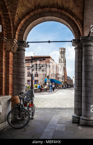 Blick durch einen Bogen in Richtung Eekhoutstraat Wollestraat Brücke und der Belfried von Brügge. Stockfoto