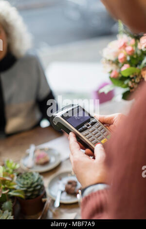 Kassierer mit der Credit card reader im Cafe Stockfoto