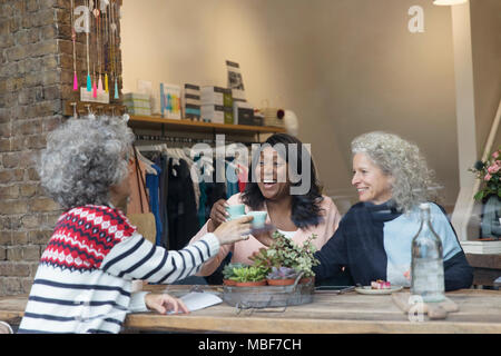 Frauen Freunde Trinken von Tee im shop Fenster Stockfoto