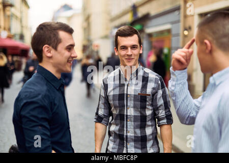 Drei Mann sprechen auf der Straße über Business Stockfoto