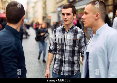 Drei Mann sprechen auf der Straße über Business Stockfoto