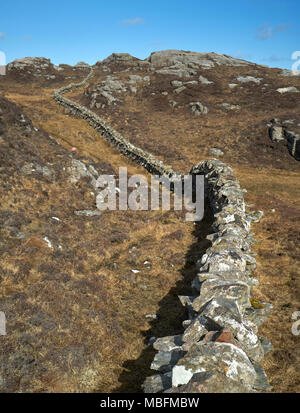 Ungewöhnliche Mauer aus Stein gebaut aus Granit Felsen schlängelt sich durch die felsige Landschaft von Uig auf der Isle of Lewis in Schottland. Stockfoto