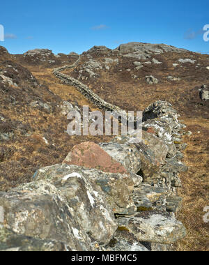 Ungewöhnliche Mauer aus Stein gebaut aus Granit Felsen schlängelt sich durch die felsige Landschaft von Uig auf der Isle of Lewis in Schottland. Stockfoto