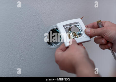 Elektriker Befestigung Kabel an die Buchse im neuen Gebäude, in der Nähe Stockfoto