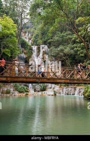 Nur wenige Touristen nehmen Fotos auf einer Brücke vor der wichtigsten fallen am Tat Kuang Si Wasserfälle in der Nähe von Luang Prabang in Laos. Stockfoto