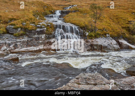 Ein Strom von Wasser über die Felsen in einen sich schnell bewegenden Fluss unten, Scottish Highlands, Schottland, UK Stockfoto