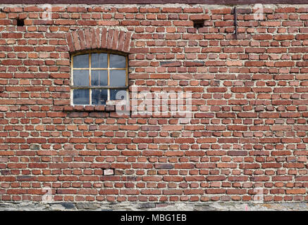 Vintage Red brick wall mit rostigen Fenster und Feld Stein Stiftung Stockfoto