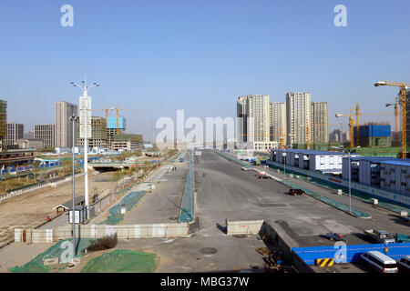 Blick hinunter eine Straße über eine große Baustelle in Shangan, eine neue Entwicklung in den westlichen Vororten von Peking, China Stockfoto