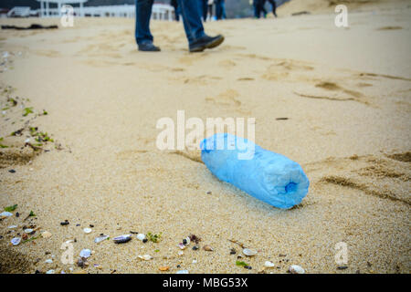 Verschmutzte Kunststoff Flasche fiel auf den Strand Stockfoto