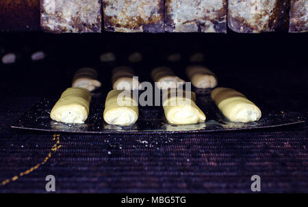 Süßes Gebäck gehen zu einem großen Ofen in einer großen Bäckerei Stockfoto
