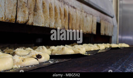 Süßes Gebäck gehen zu einem großen Ofen in einer großen Bäckerei Stockfoto