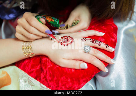 Henna Design Tattoos. Frauen Rosen Anwendung Henna Tattoo auf Frauen Hände. Frau zieht mehendi auf den Händen. Artist Anwendung Henna Tattoo auf Braut Hände. Stockfoto